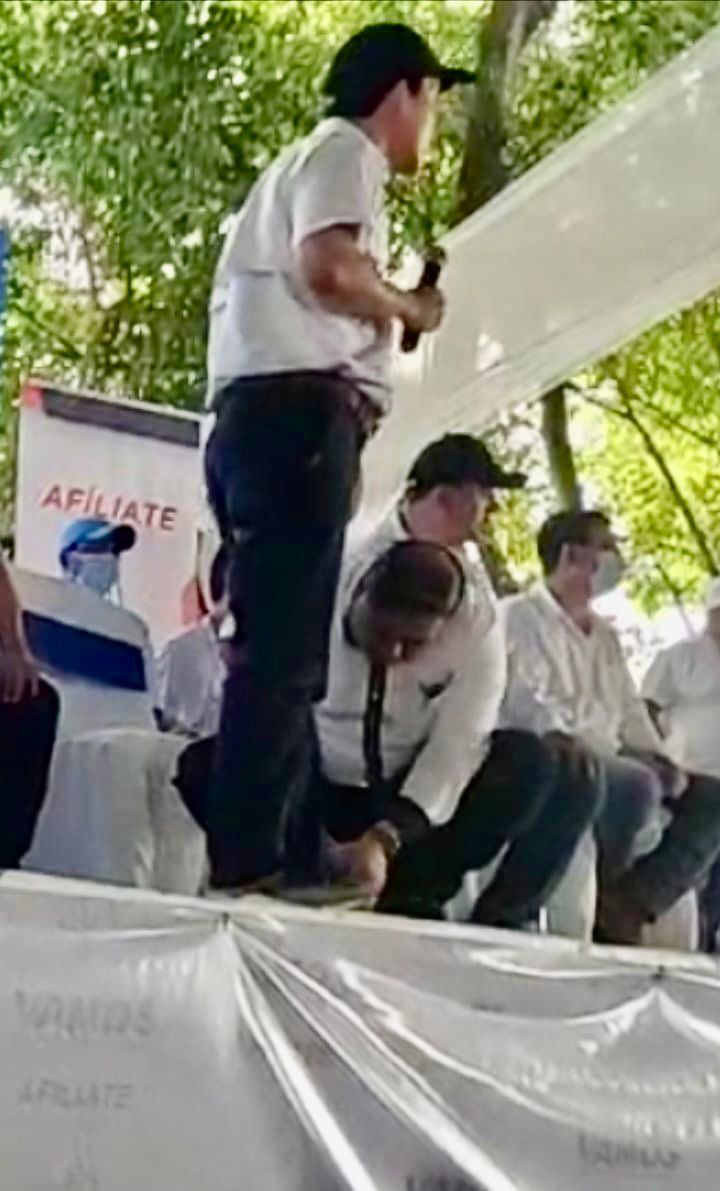 Miguelito a la tarima, mientras oficialista se hinca a amarrar su zapato imagen